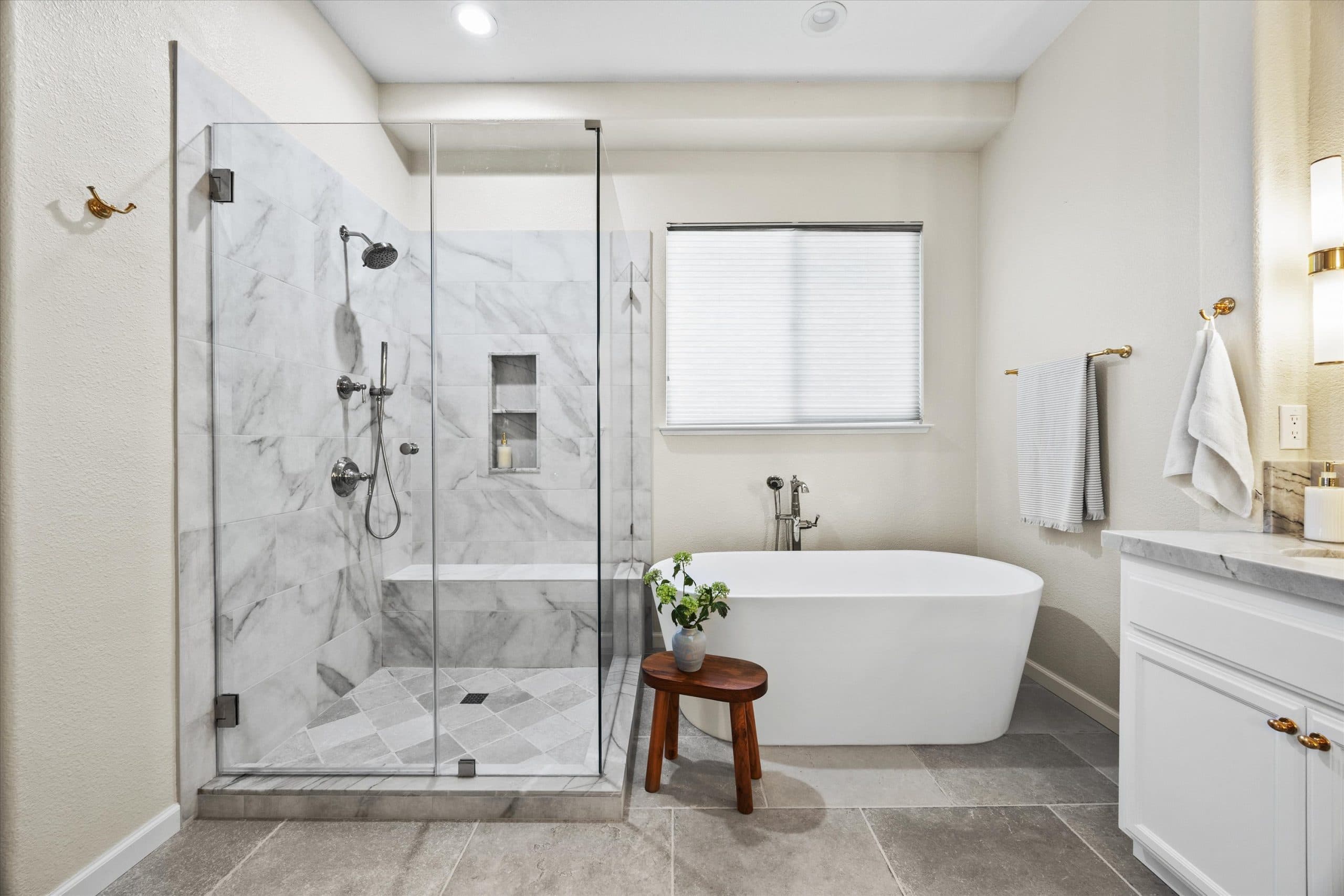 Completed master bathroom with freestanding tub, walk-in shower, and marble tile throughout