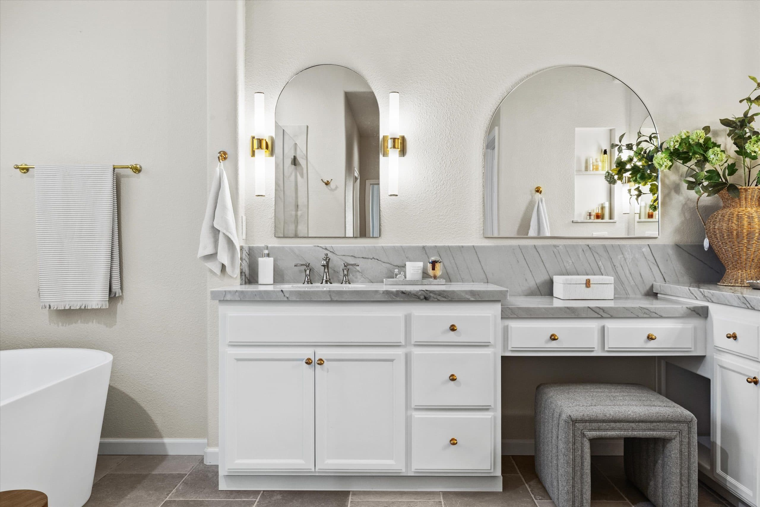 Detail view of white vanity cabinet with mixed-metal hardware and quartzite countertop