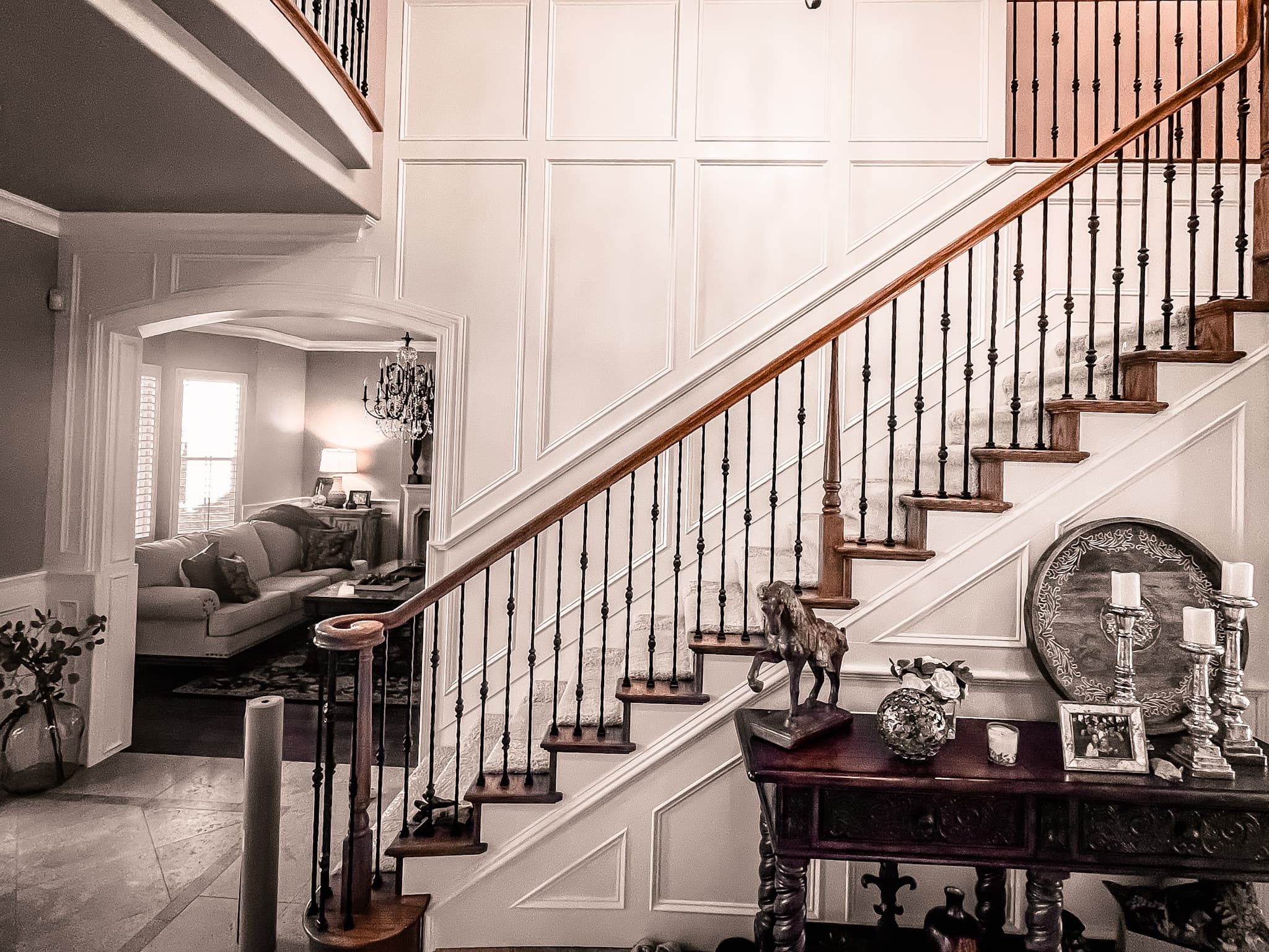 Grand staircase with custom wainscoting, board-and-batten paneling, and architectural trim details