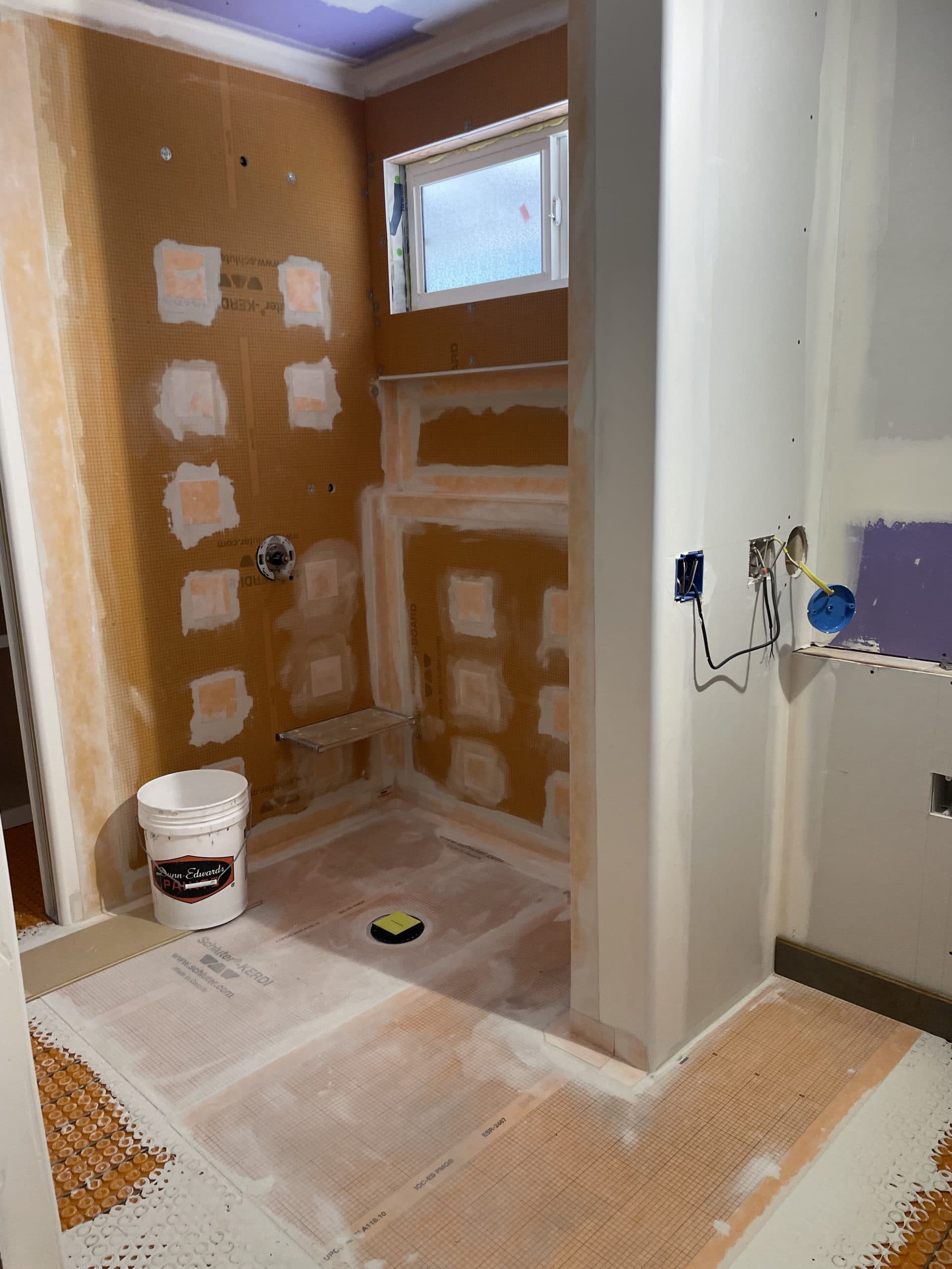 Heated floor membrane covering bathroom floor during Sacramento remodel