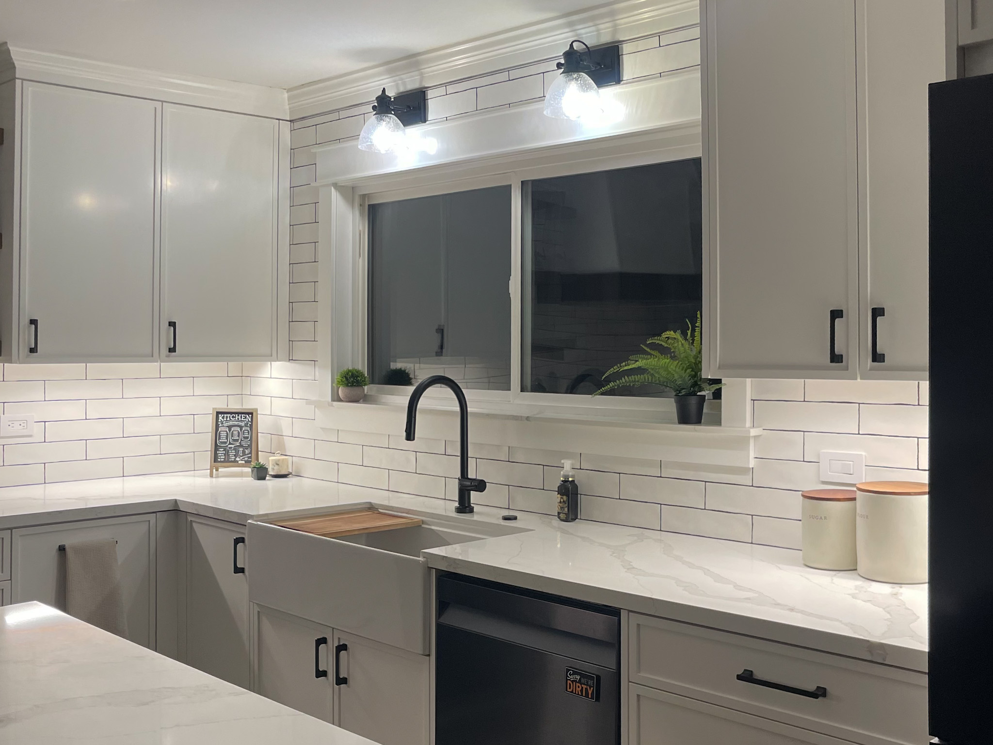 Updated kitchen with elegant white cabinetry and contemporary black appliances, highlighting a successful remodel.