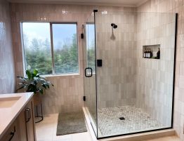 Renovated modern bathroom with a stylish glass shower door, highlighting contemporary design elements.