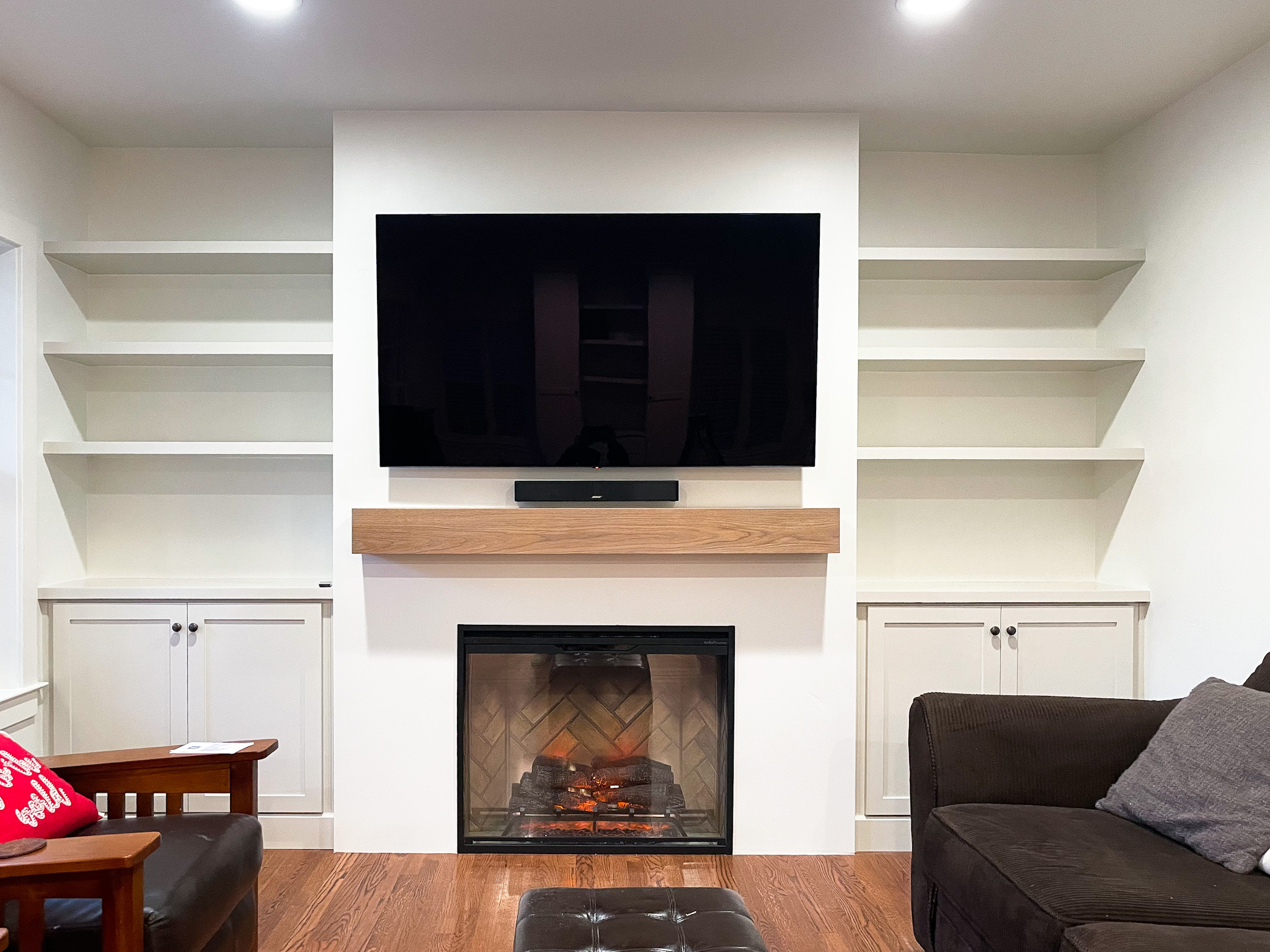 A contemporary living room with a beautifully renovated fireplace and a television, offering a perfect blend of warmth and entertainment.